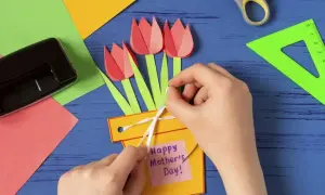 Ręcznie robiony prezent dla mamy od dziecka: żółta doniczka z papierowymi tulipanami i karteczką "Happy Mother's Day".