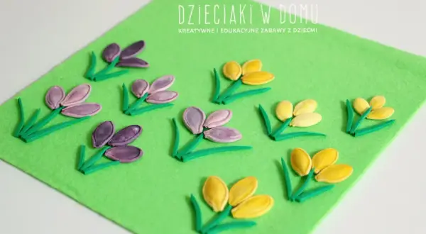 Wiosenne kwiaty z pestek dyni na zielonym filcu. Dzieciaki w domu tworzą piękne, kolorowe kompozycje.