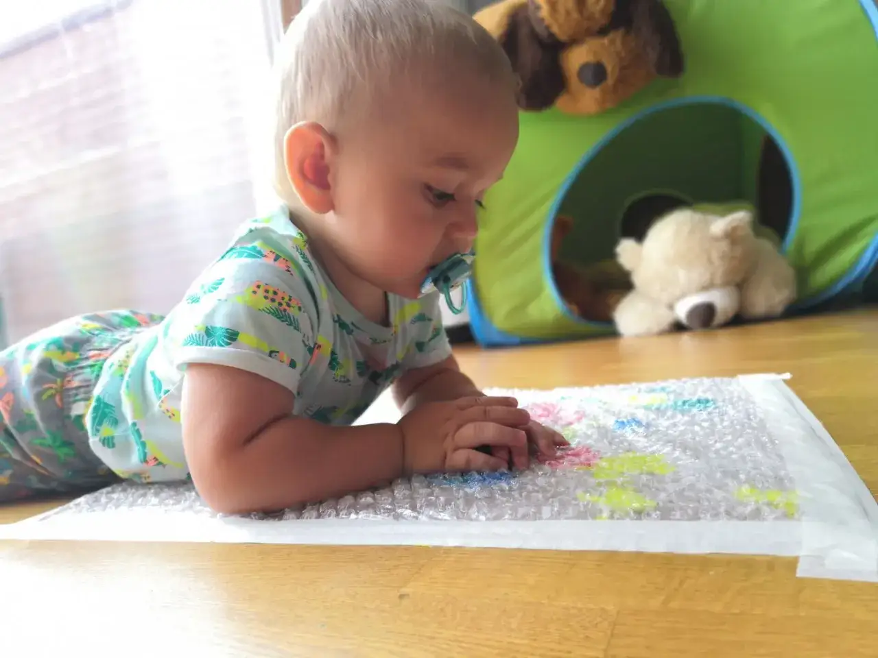 Malowanie na folii bąbelkowej to świetna zabawa! Dziecko odkrywa kolory i tekstury, a pluszowe misie kibicują mu z tunelu.