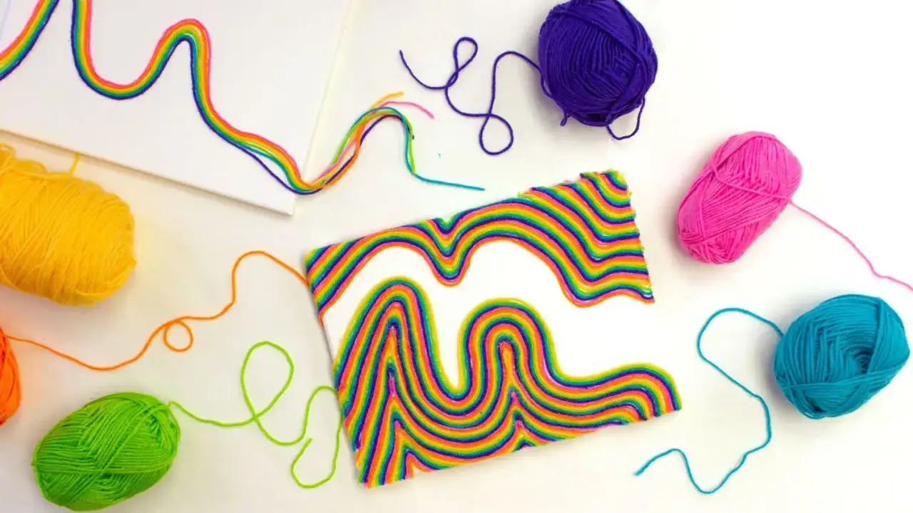 Kolorowe sznurki tworzą tęczowe wzory na pł&oacute;tnie. To świetne string art dla dzieci, kt&oacute;re rozwijają kreatywność.